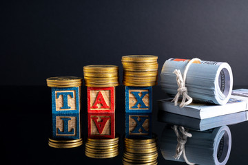 Coins stacking and tax letter cube with low light view.