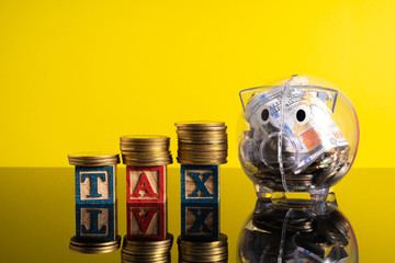 TAX letter and stacking coins with financial concept. Image in low light view.