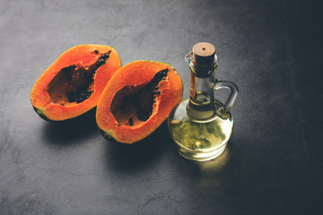 Papaya seed Oil with Raw Papita over moody background. selective focus
