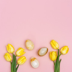 Easter composition with natural flower of tulips and decorative eggs from gemstone onyx. Spring Easter holiday pattern for greeting card with copy space. Flat lay.