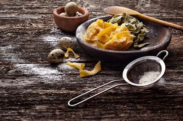Quail eggs with pasta in a wooden  plate on the old background. Rustic style on dark wood background.