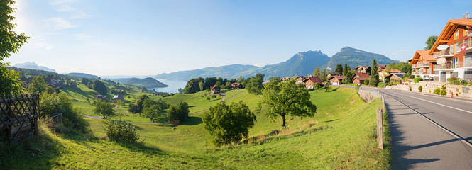 idyllic tourist resort Krattigen, green pasture and view to lake Thunersee, switzerland