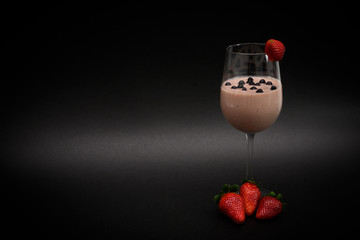 Fresh organic smoothie in a wine glass with natural blueberries in a drink and with three...