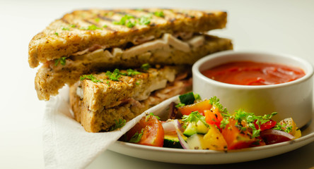 Handmade sandwich with chicken breast and beechwood smoked bacon served with a mixed salad and tomato sauce