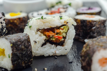 Mix veggie sushi and fish sushi on the black stone plate