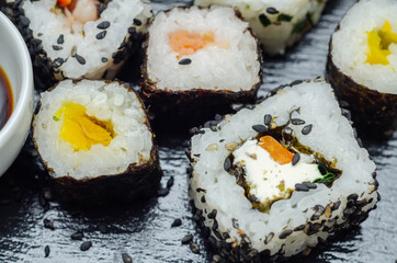 Mix veggie sushi and fish sushi on the black stone plate