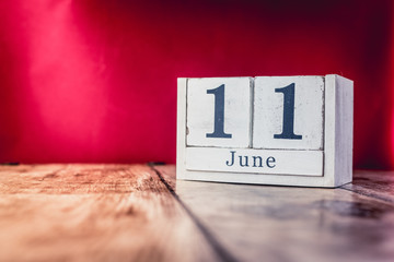 June 11th. Day 11 of month, calendar on business office table, workplace with vivid maroon red...