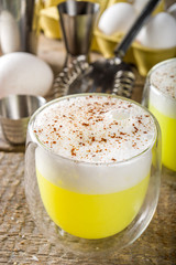 Autumn Homemade Bourbon Egg Flip Cocktail with spices, wooden background with ingredients