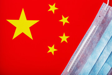 Medical mask on the background of the Chinese flag. Disposable face masks for viruses, Coro novirus.