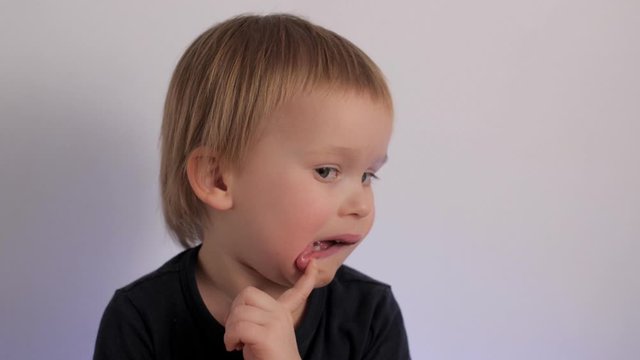 Close up portrait of doubt little cute child feeling confused hesitate and biting lips