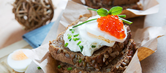 Sandwiches with salmon red caviar and boiled eggs.