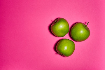 Green apple on pink background. Flat lay, top view, copy space . Food dietary concept.
