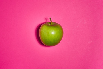 Green apple on pink background. Flat lay, top view, copy space . Food dietary concept.