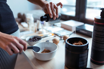 A young woman preparing chocolate cream with natural ingredients for body treatment. Body care concept.