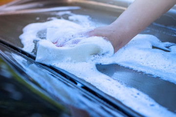 A woman washes the car