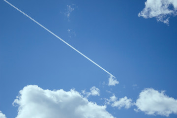A lone plane flies in the blue sky
