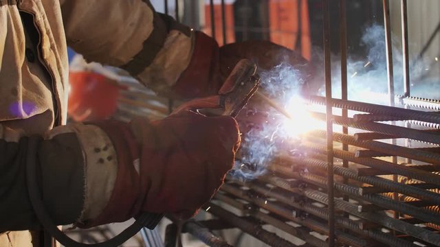 Wedler. Welder works at a construction site. Smoke from welding. Electric arc welding.