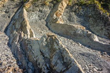 Rocky coast of Black Sea in village of Olginka, Tuapse district. Natural textures protruding on steep slopes of Caucasus Mountains. Close-up. Rock fragments and stones of different sizes as background