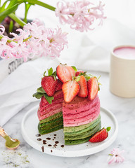 Multicolored pancakes from the matchа and strawberries