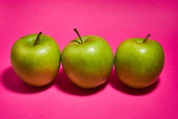 Green apple on pink background. Flat lay, top view, copy space . Food dietary concept.