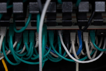 Inside of a server room. A lot of different cables in connectors. Equipment service in datacenter. A bunch of wires.