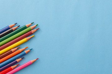 Colored pencils composition on blue background.