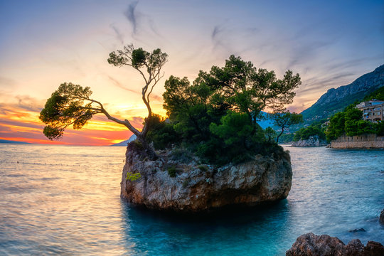 Amazing sunset seascape, scenic view of Brela stone (kamen Brela), a symbol of Adriatic resort and popular tourist attraction. Travel background, Punta Rata beach, Makarska riviera, Dalmatia, Croatia