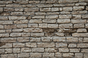 The brown and grey  cobblestone or brick tower, fortress or castle wall background or texture