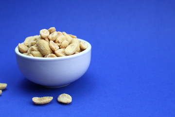 Tasty salted peanuts in a white plate