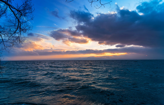 Beautiful landscape. Bright colorful sunset with dramatics clouds over the lake. 