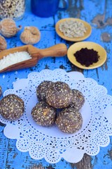 Vegan energy balls with Maqui berry powder, acai powder, quinoa, fig, sunflower seed and coconut flakes on doily paper