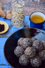 Maqui berry energy balls with quinoa, fig, sunflower seed and coconut flakes. Blue background
