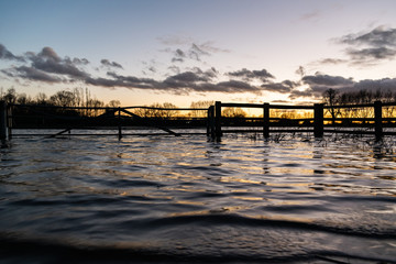 Floods in Thame town, Oxfordshire winter floded lands, sumset by the water, river overflow for new animal habitat
