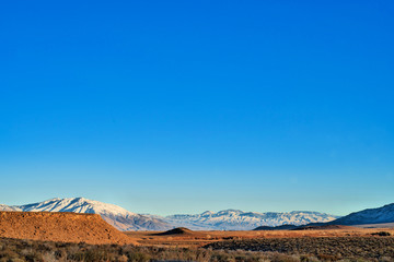 blue sky copy space above desert valley and snowy mountains wilderness landscape