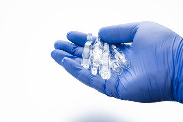 Medical ampoules with the palm of a doctor. Medicines for vaccination in glass bottles.