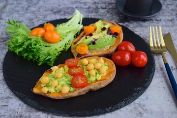 Sweet potato toast with avocado, almond butter, tomato, chickpea, lettuce and hemp seeds