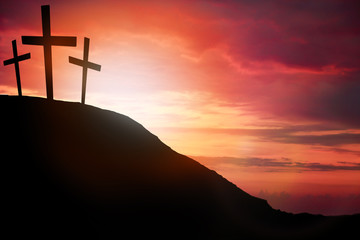 Silhouette cross on Calvary mountain sunset background. Easter concept