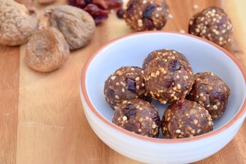 Fig cranberry quinoa energy balls. Vegan protein balls. Wooden background