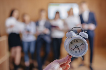 classic alarm clock on background of blurry people