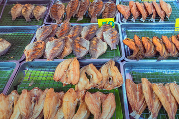Many kinds of deep fried fish on tray for sale at street food in Thailand.