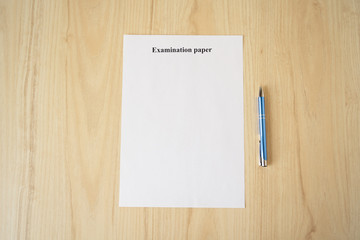 Empty examination paper for university with pen on the school desk. Copyspace. Mockup. Flat lay