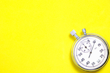 Mechanical stopwatch on a yellow background.