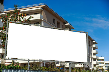 Blank white advertising billboard in front of the building