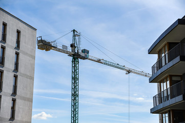 Construction crane between apartment buildings on a sunny summer day