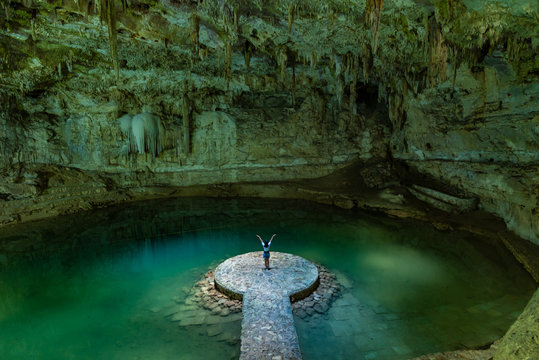 Woman enjoying the view of Suytun Cenote from the top Yucatan Mexico North America