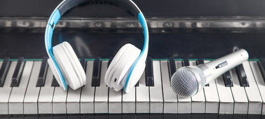 Headphones with a microphone on the piano keyboard. Music