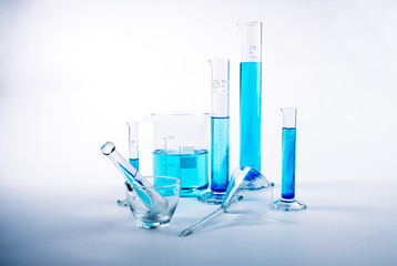 Laboratory test equipment with blue liquid inside on white background