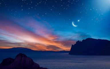 Ramadan background with crescent, stars and glowing clouds with ray from skies above mountains and sea. Month of Ramadan is that in which was revealed Quran. - obrazy, fototapety, plakaty