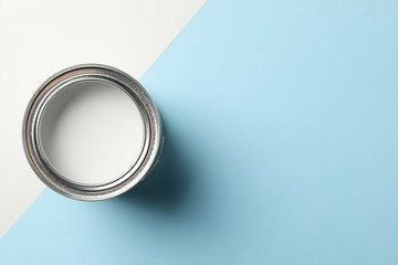 Can of white paint on two tone background, top view