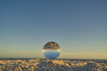 Nahaufnahme einer Glaskugel am Strand auf Sanibel Island mit Meer und Horizont im Hintergrund